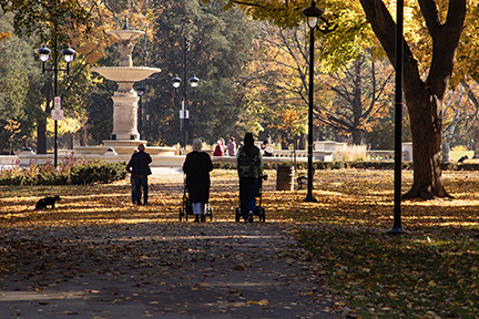 People walking to Gage Park Fountain in Fall colours